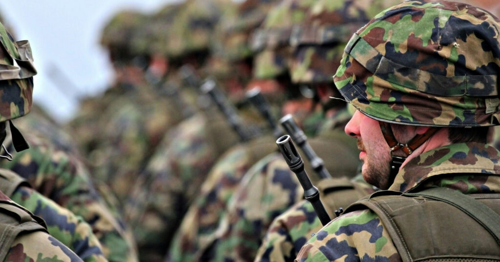 Group of British soldiers in uniform standing together during military training.