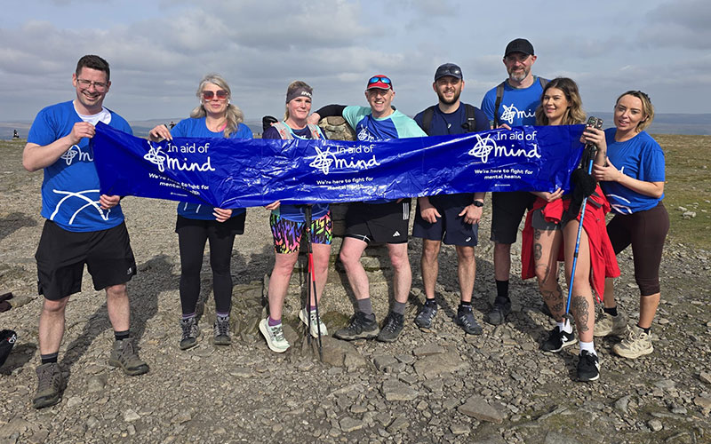 Major Recruitment team holding a MIND charity banner after completing the Yorkshire Three Peaks Challenge